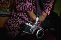 Armless professional photographer Rusidah, 44, carries out camera maintenance on March 13, 2012 in Purworejo, Indonesia. (Photo by Ulet Ifansasti/Getty Images)