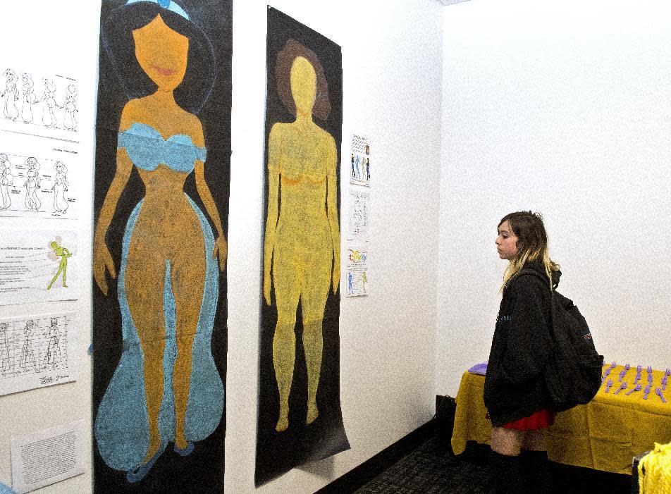 In this Friday, Dec. 9, 2016, photo, Sam Lane looks at the artwork "Female Figures" prior to the Animated Women symposium at California Institute of the Arts, in Valencia, Calif. The California Institute of the Arts was created partly by Walt Disney's desire to bring more top-flight animators into the profession. And it has during its 47 years, though for a long time almost all were men. Now, nearly three-quarters of CalArts' more than 250 animation students are women, and there's a new goal: Ensure that when they land jobs, they get to draw female characters reflective of the real world and not just the nerds, sex bombs, tomboys or ugly villains who proliferate now. (AP Photo/Mark J. Terrill)