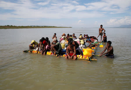 Rohingya refugees sail towards the bank of Naf River on a makeshift raft after crossing the Bangladesh-Myanmar border, at Sabrang in Teknaf, near Cox's Bazar, Bangladesh, November 11, 2017. Picture taken November 11, 2017. REUTERS/Navesh Chitrakar