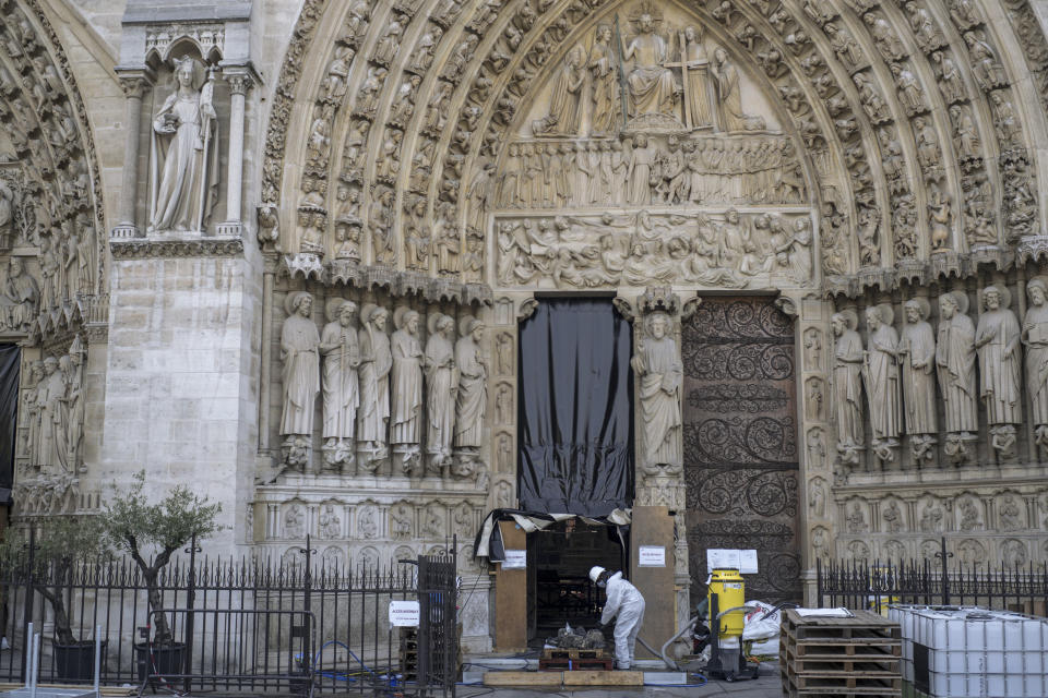 A worker cleans debris, during preliminary work to repair the fire damage at the Notre-Dame de Paris Cathedral, in Paris, France, Wednesday, July 24, 2019. (AP Photo/Rafael Yaghobzadeh, Pool)