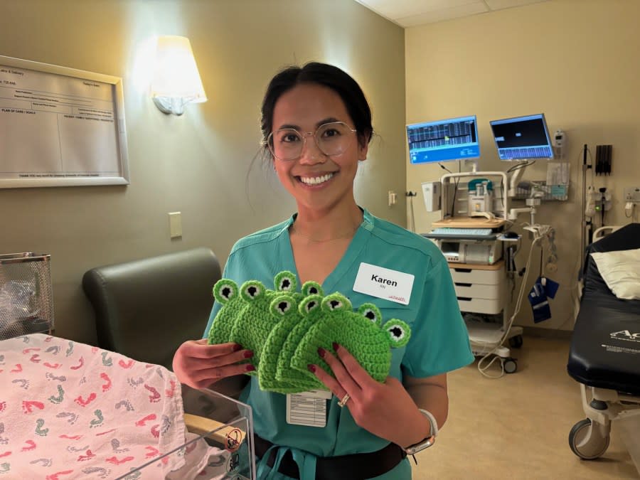 Labor and Delivery RN, Karen Agee, poses with the infant hats she crocheted to help celebrate leap day.