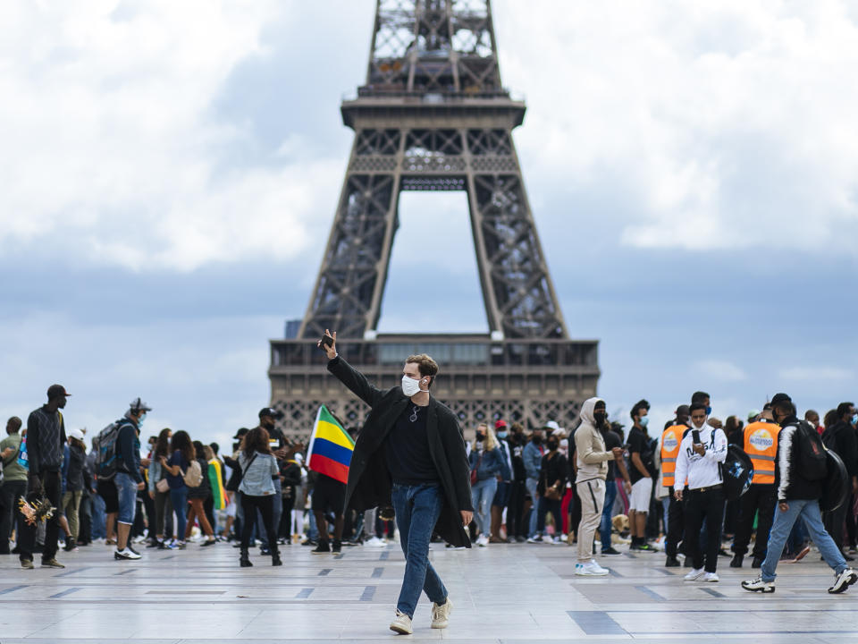 People wearing face masks stroll at Trocadero plaza near the Eiffel Tower, in Paris, Saturday, Aug. 29, 2020. France registered more than 7,000 new virus infections in a single day Friday, up from several hundred a day in May and June, in part thanks to ramped-up testing. Masks are now required everywhere in public in Paris as authorities warn that infections are growing exponentially. (AP Photo/Kamil Zihnioglu)