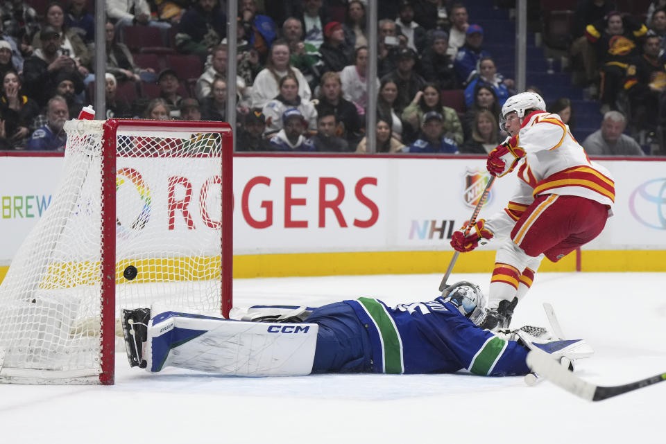 Calgary Flames' Tyler Toffoli scores against Vancouver Canucks goalie Thatcher Demko in overtime of an NHL hockey game Friday, March 31, 2023, in Vancouver, British Columbia. (Darryl Dyck/The Canadian Press via AP)