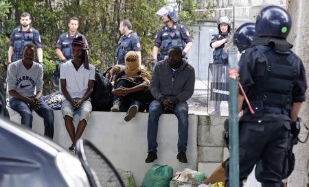 A group of migrants is surrounded by Italian police during their evacuation from the Saint Ludovic border crossing on the Mediterranean Sea between Vintimille, Italy and Menton, France, June 16, 2015. REUTERS/Eric Gaillard