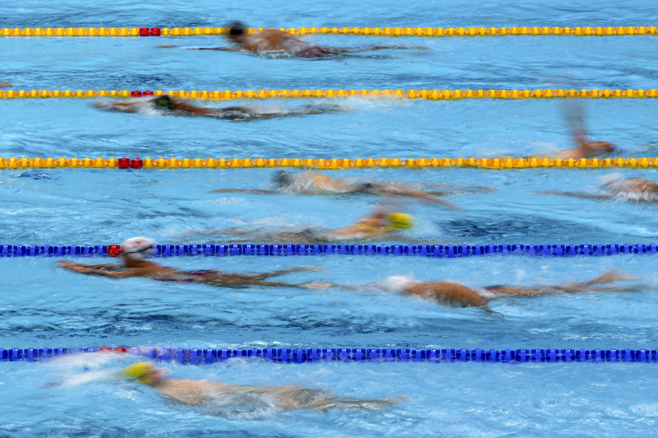 FILE - In this July 21, 2021, file photo, athletes exercise during a swimming training session at the Tokyo Aquatics Centre at the 2020 Summer Olympics in Tokyo, Japan. With hundreds of swimmers scrambling to get their warmup done at the same time, multiple athletes in each lane, everyone diving over one another and some competitors using snorkels, kickboards and other paraphernalia, warmup is organized chaos. (AP Photo/Matthias Schrader, File)