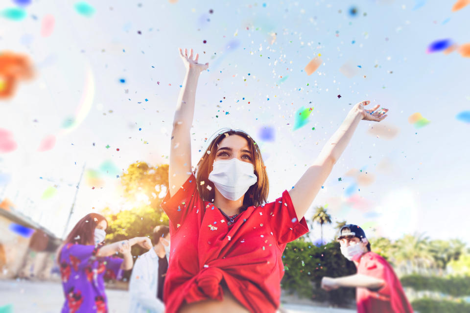 Group of teenagers celebrating at a party wearing face masks during Covid-19 Coronavirus epidemic spread.