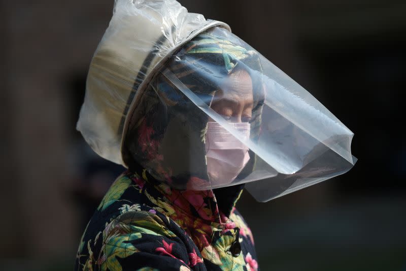 A resident wears a makeshift protective face shield at a residential compound in Wuhan