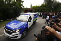 An ambulance carrying the body of Diego Maradona leaves his house in Buenos Aires, Argentina, Wednesday, Nov. 25, 2020. The Argentine soccer great who was among the best players ever and who led his country to the 1986 World Cup title before later struggling with cocaine use and obesity, died from a heart attack on Wednesday at his home in Buenos Aires. He was 60. (AP Photo/Marcos Brindicci)