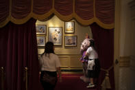 In this Oct. 11, 2019 photo, visitors pose for photos with a bear at Hong Kong Disneyland in Hong Kong. The body-blow of months of political protests on Hong Kong’s tourism is verging on catastrophic for one of the world’s great destinations. Geared up to receive 65 million travelers a year, the city’s hotels, retailers, restaurants and other travel-oriented industries are suffering. But some intrepid visitors came specifically to see the protests and are reveling in deep discounts and unusually short lines at tourist hotspots.(AP Photo/Felipe Dana)