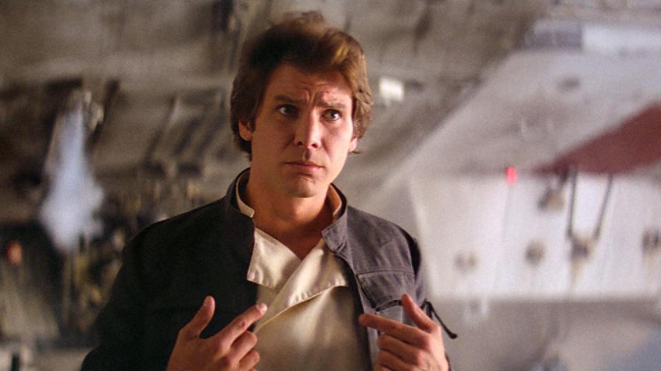 Han Solo looks surprised while pointing at himself
