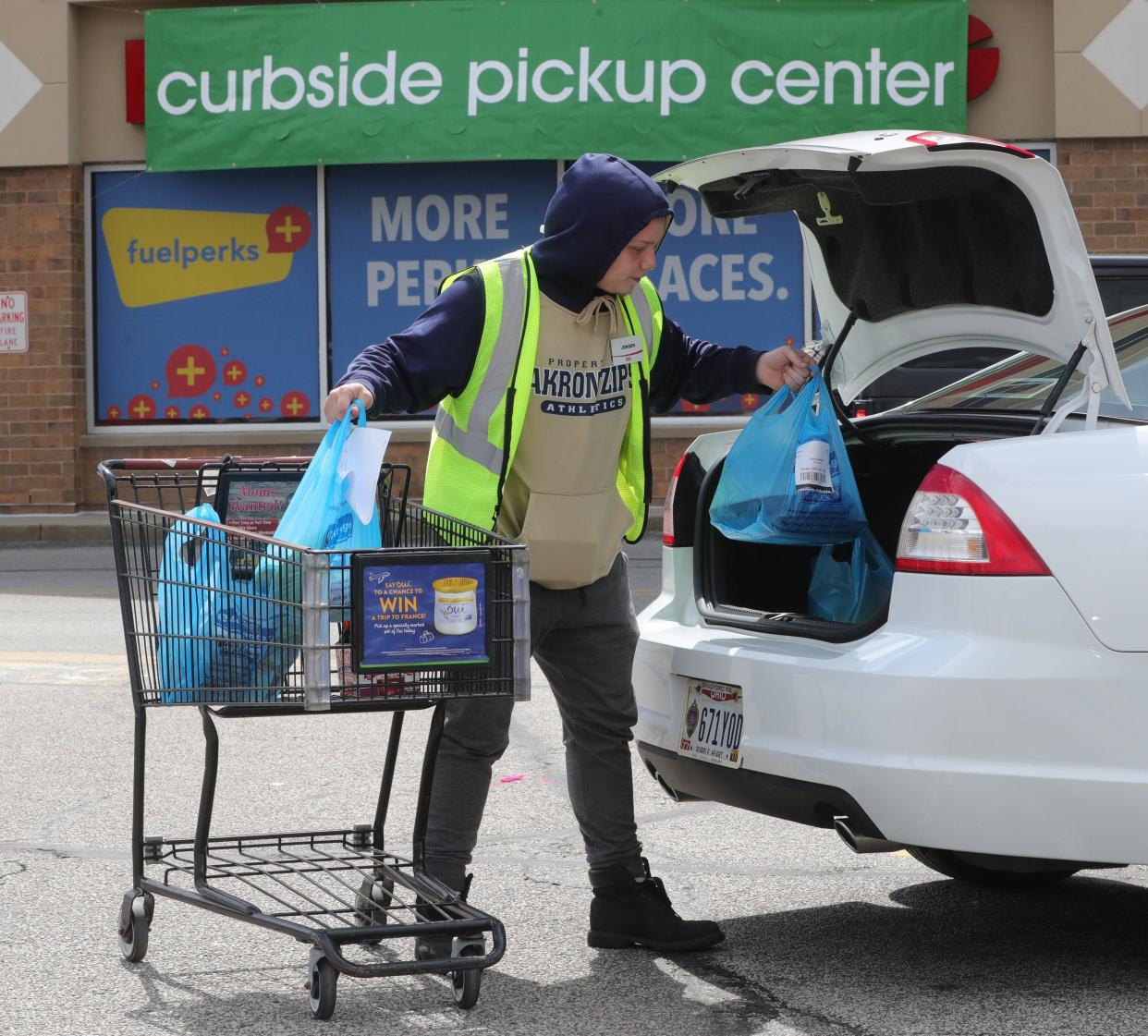 Giant Eagle employee Jensen Barkman loads bags of groceries into the trunk in the Cleveland area. The chain is eliminating plastic bags at its stores.