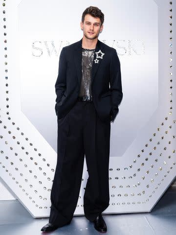 <p>Gotham/FilmMagic</p> Brandon Flynn poses in Versace and Swarovski at the jewelry brand's flagship store grand opening in New York City