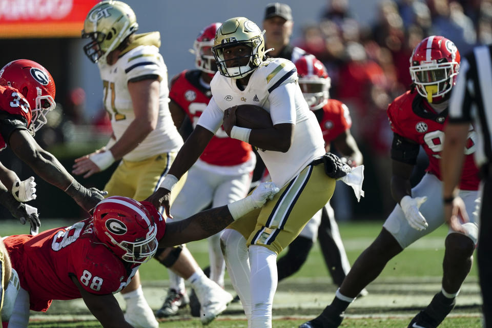 Georgia Tech quarterback Taisun Phommachanh (17) tries to escape the grasp of Georgia defensive lineman Jalen Carter (88) during the first half of an NCAA college football game Saturday, Nov. 26, 2022 in Athens, Ga. (AP Photo/John Bazemore)