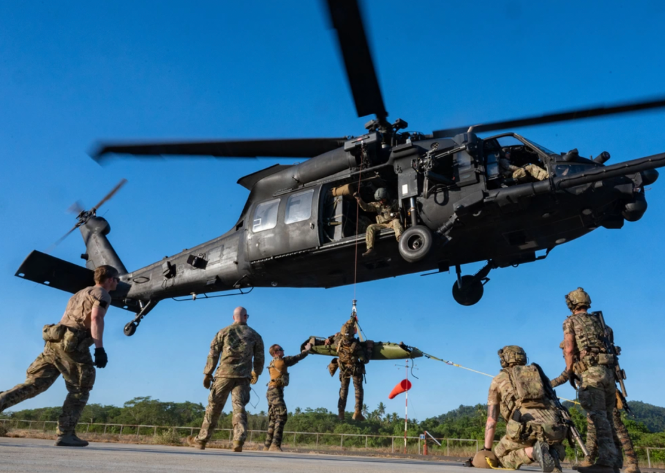 MH-60 helicopter with Night Stalker operators performing rescue training on an airstrip.