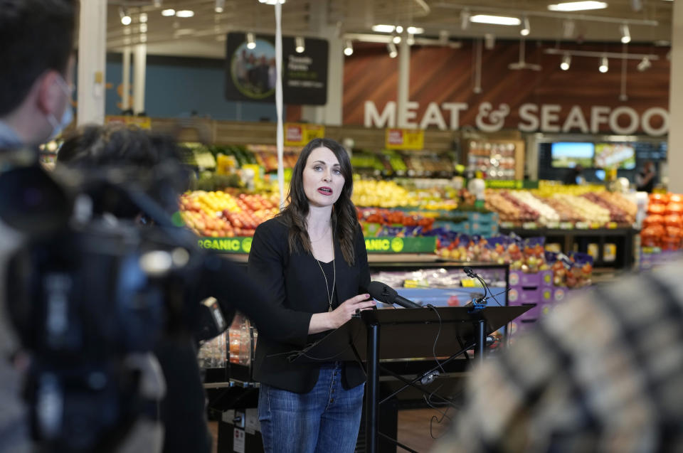 Jessica Trowbridge, center, spokesperson for the King Soopers grocery chain, speaks to media members about the Table Mesa King Soopers during a media tour Tuesday, Feb. 8, 2022, in Boulder, Colo. Ten people were killed inside and outside the store when a gunman opened fire on March 22, 2021. Trowbridge said a survey conducted by the company found that the store's workers and customers overwhelmingly wanted the store to reopen and the company heeded changes they asked for in renovations. (AP Photo/David Zalubowski)