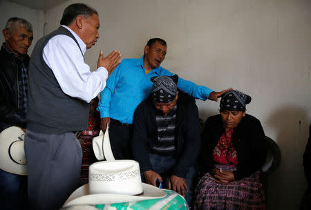 A pastor prays along Gilberto Gomez and Lidia Gonzalez in memory of their daughter Claudia Gomez, a 19-year old Guatemalan immigrant who was shot by an U.S. Border Patrol officer, at their home in San Juan Ostuncalco, Guatemala May 27, 2018. REUTERS/Luis Echeverria