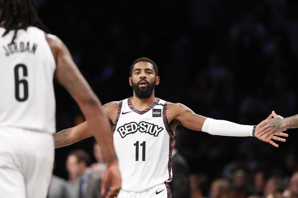 Brooklyn Nets guard Kyrie Irving (11) slaps hands with his teammates, including DeAndre Jordan (6), during the first half of an NBA basketball game against the Atlanta Hawks, Sunday, Jan. 12, 2020, in New York. (AP Photo/Kathy Willens)