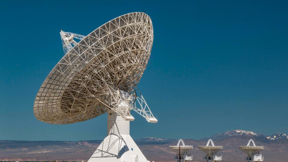 A huge satellite dish with three small satellite dishes located at the Owens Valley Radio Observatory in the Owens Valley in California.