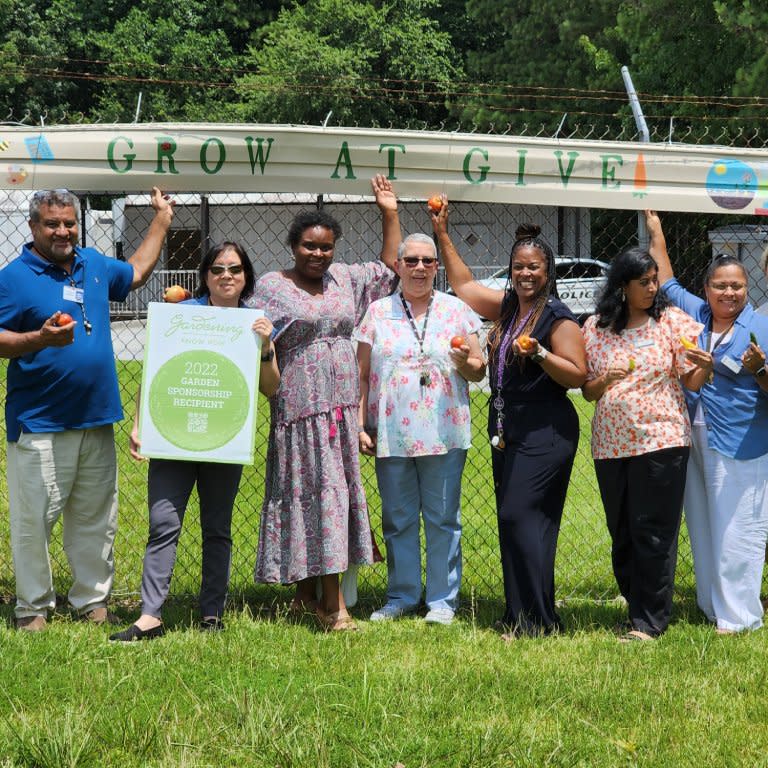  A group of smiling people holding a sign. 