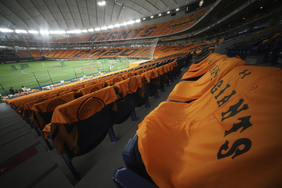 Empty seats with orange jerseys are placed during a practice session prior to an opening baseball game between the Yomiuri Giants and the Hanshin Tigers at Tokyo Dome in Tokyo Friday, June 19, 2020. Japan's professional baseball regular season will be kicked off Friday without fans in attendance because of the threat of the spreading coronavirus. (AP Photo/Eugene Hoshiko)