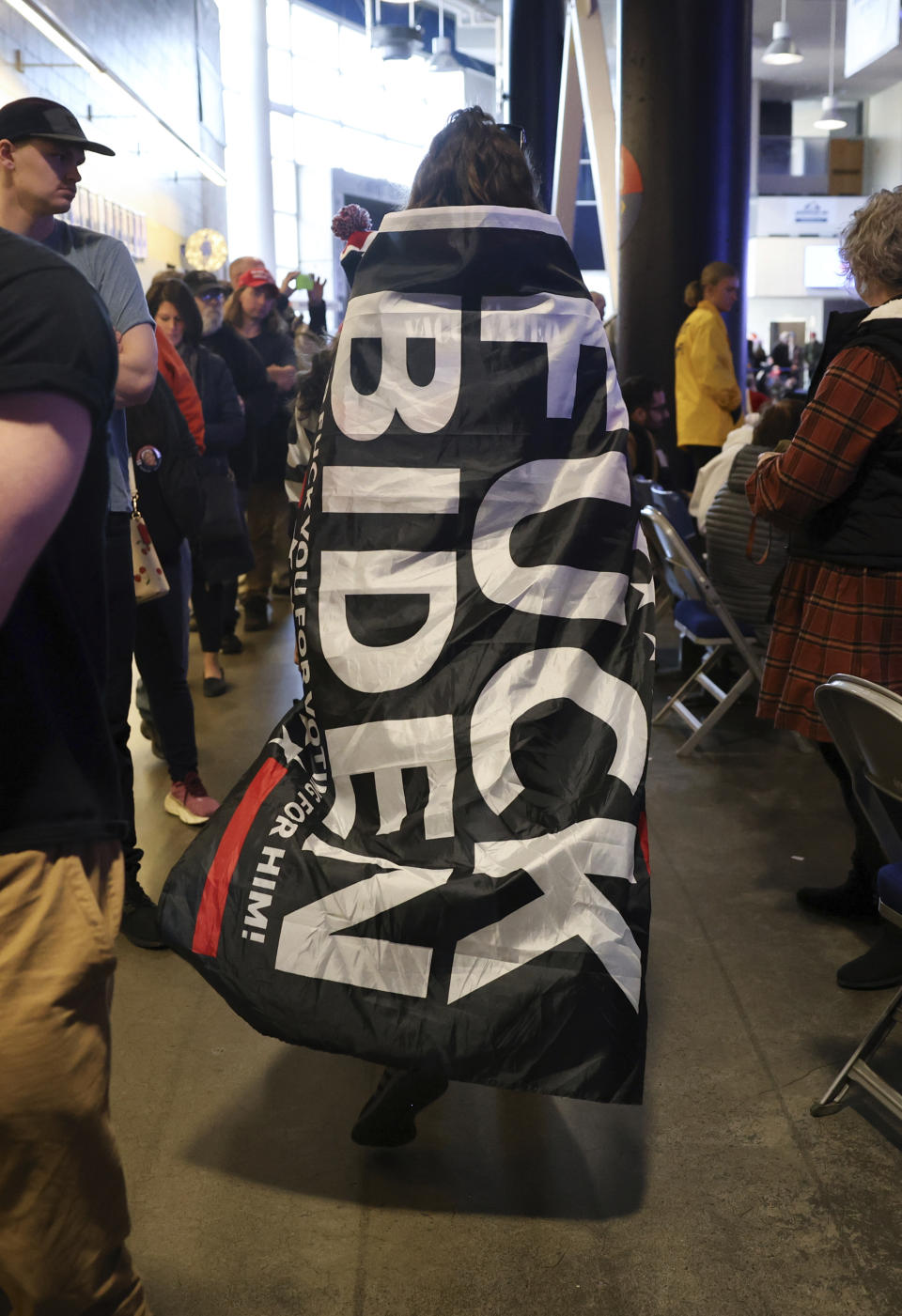 An attendee wears a flag during a campaign rally for Former president Donald Trump Saturday Dec. 16, 2023, in Durham, N.H. (AP Photo/Reba Saldanha)