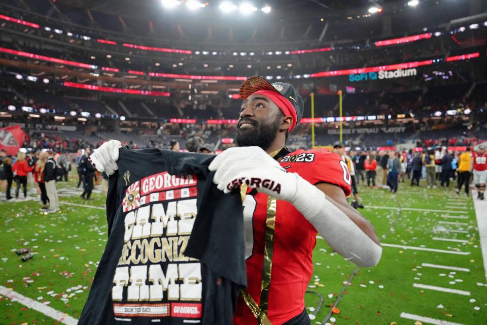 Georgia Bulldogs linebacker Rian Davis holds up a shirt as he celebrates after winning the CFP national championship game.