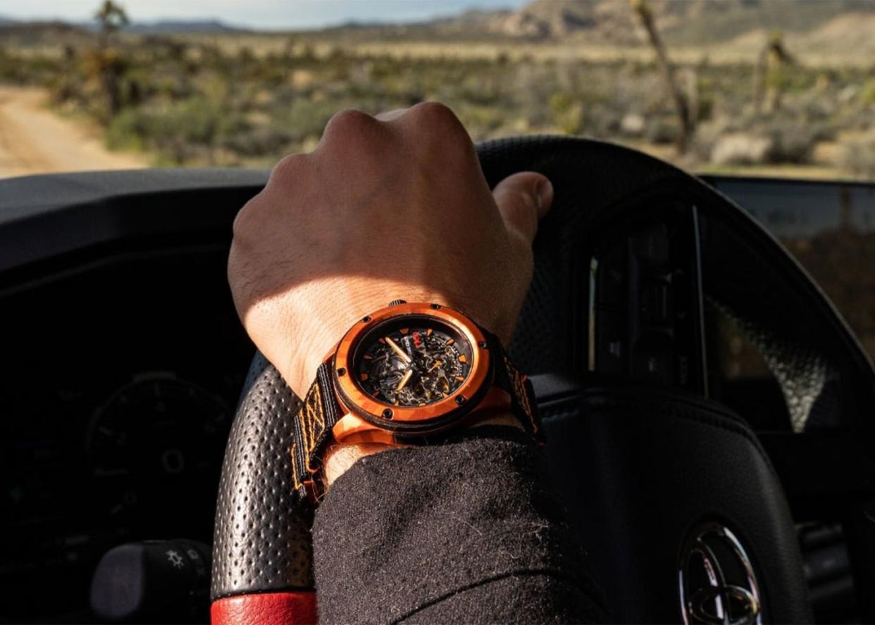 man wearing an original grain toyota trd solar watch while driving with one hand on the wheel