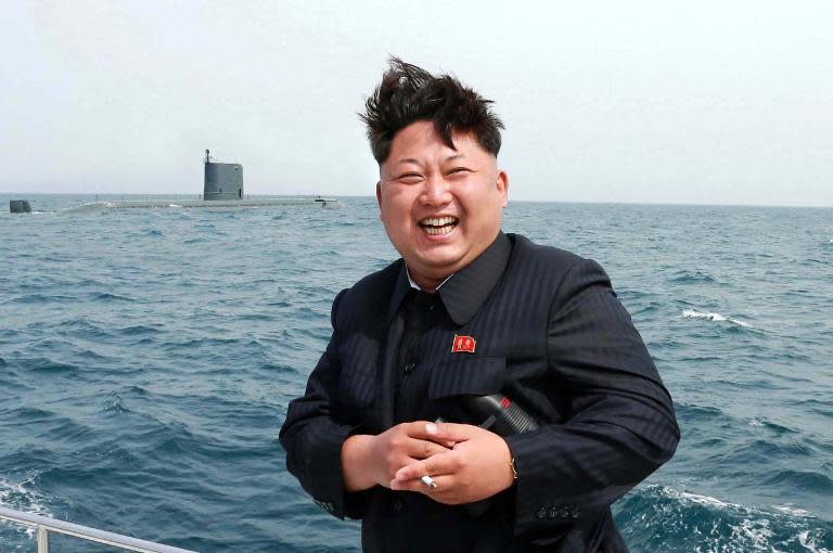 North Korean leader Kim Jong-Un smiles while observing an underwater test-fire of a submarine-launched ballistic missile at an undisclosed location at sea in this official state media image from May 9, 2015