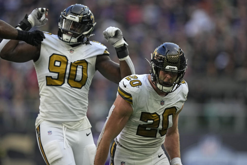 New Orleans Saints defensive end Tanoh Kpassagnon (90) and New Orleans Saints linebacker Pete Werner (20) celebrate after a sack on Minnesota Vikings quarterback Kirk Cousins (8) during an NFL match between Minnesota Vikings and New Orleans Saints at the Tottenham Hotspur stadium in London, Sunday, Oct. 2, 2022. (AP Photo/Frank Augstein)