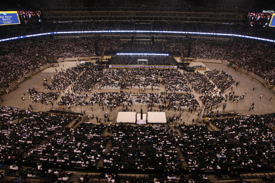A large crowd of Orthodox Jewish men and women are gathered at MetLife stadium in East Rutherford, N.J, Wednesday, Aug. 1, 2012, during the celebration Siyum HaShas. The Siyum HaShas, marks the completion of the Daf Yomi, or daily reading and study of one page of the 2,711 page book. The cycle takes about 7½ years to finish.This is the 12th put on by Agudath Israel of America, an Orthodox Jewish organization based in New York. Organizers say this year's will be, by far, the largest one yet. More than 90,000 tickets have been sold, and faithful will gather at about 100 locations worldwide to watch the celebration. (AP Photo/Mel Evans)