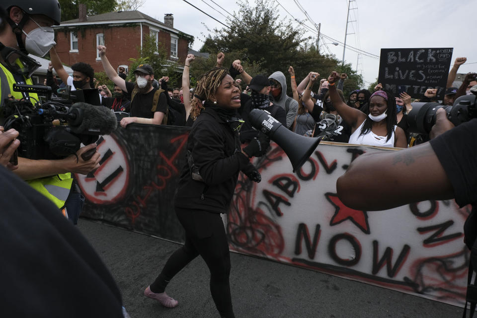 A protestor calls for the crowd to 