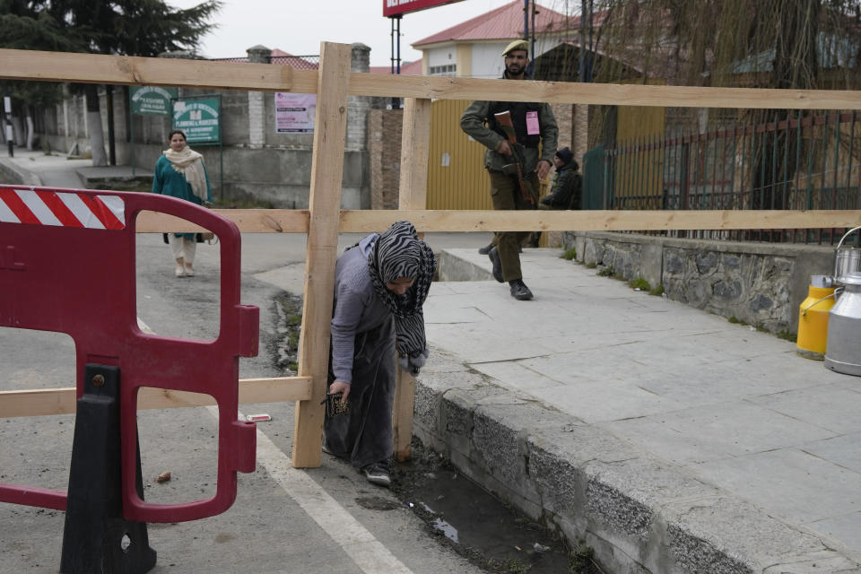 A woman tries to make her way through a road barricade set up by security forces ahead of Indian Prime Minister Narendra Modi's visit to Srinagar, Indian controlled Kashmir, Wednesday, March 6, 2024. Modi is scheduled to address a public rally in Srinagar on Thursday. (AP Photo/Mukhtar Khan)