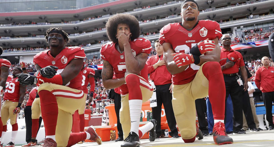 From left, 49ers outside linebacker Eli Harold, quarterback Colin Kaepernick, and safety Eric Reid on Oct. 2, 2016, during the national anthem. (AP)