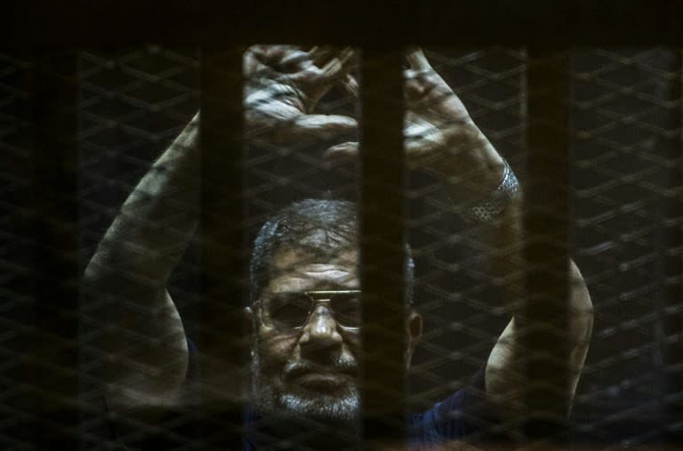 Ousted Egyptian president Mohamed Morsi gestures from the defendants cage as he attends his trial at the police academy on the outskirts of the capital Cairo, June 2, 2015