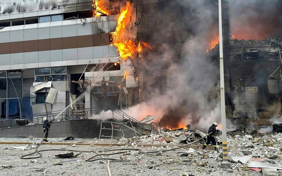 Firemen tackle a burning building in Kyiv hit by the Russian attack