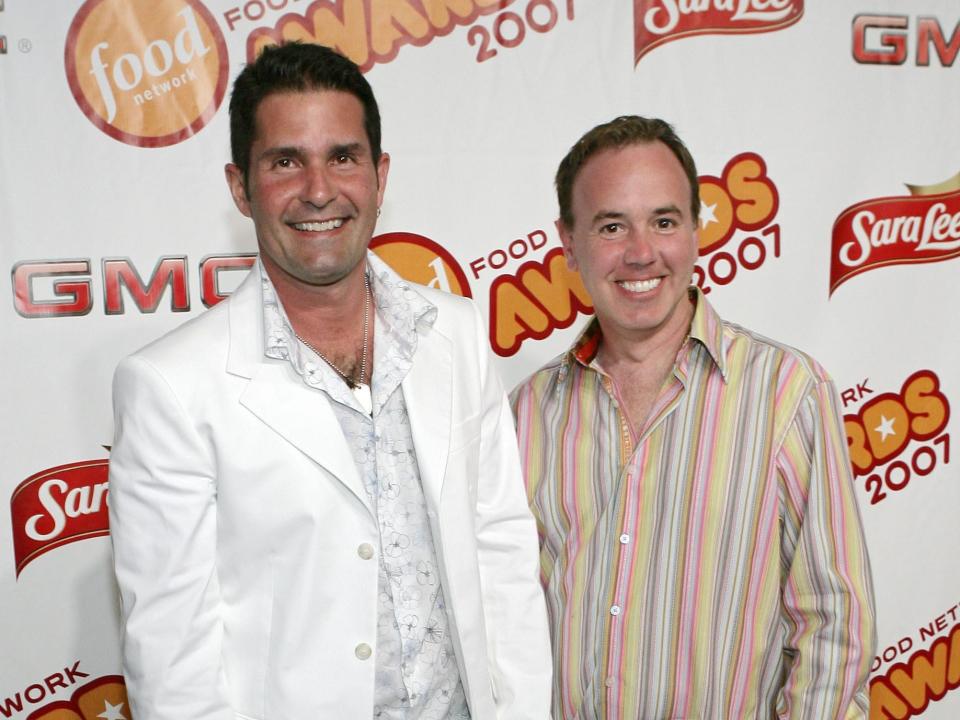 Dan and Steve smiling in button-down shirts in front of a backdrop.