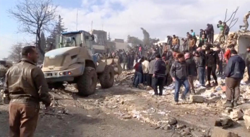 People and a bulldozer moving debris after a fuel truck exploded in Azaz