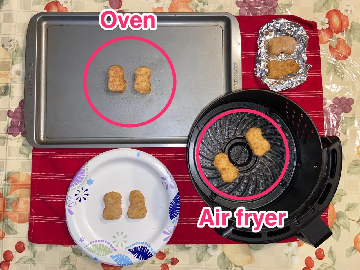 An overhead flat lay of a silver baking sheet with two nuggets in a red circle with the label "oven," a paper plate with two nuggets, an air fryer basket with two nuggets with the label "air fryer," and aluminum foil with two nuggets.