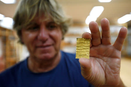 Belgrade archaeology institute chief archaeologist Miomir Korac displays recently found golden amulet at the Viminacium site, around 100km east from Belgrade, Serbia August 8, 2016. Picture taken August 8, 2016. REUTERS/Djordje Kojadinovic