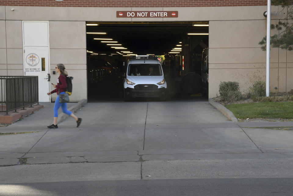 A woman walks past an ambulance bay as a STAR van exits in Denver on Thursday, Oct. 20, 2022. The STAR program uses clinicians and EMTs or paramedics to respond to nonviolent mental health crises, instead of police. Data gathered by The Associated Press show at least 14 of the 20 most populous U.S. cities are hosting or starting such programs, sometimes called civilian, alternative or non-police response teams. They span from New York and Los Angeles to Columbus, Ohio, and Houston, and boast annual budgets that together topped $123 million as of June 2023, the AP found. (AP Photo/Thomas Peipert)