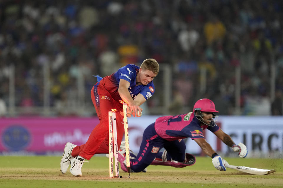 Royal Challengers Bengaluru's Cameron Green, left, breaks the stumps to run-out Rajasthan Royals' Dhruv Jurel, right, during the Indian Premier League eliminator cricket match between Royal Challengers Bengaluru and Rajasthan Royals in Ahmedabad, India, Wednesday, May 22, 2024. (AP Photo/Ajit Solanki)