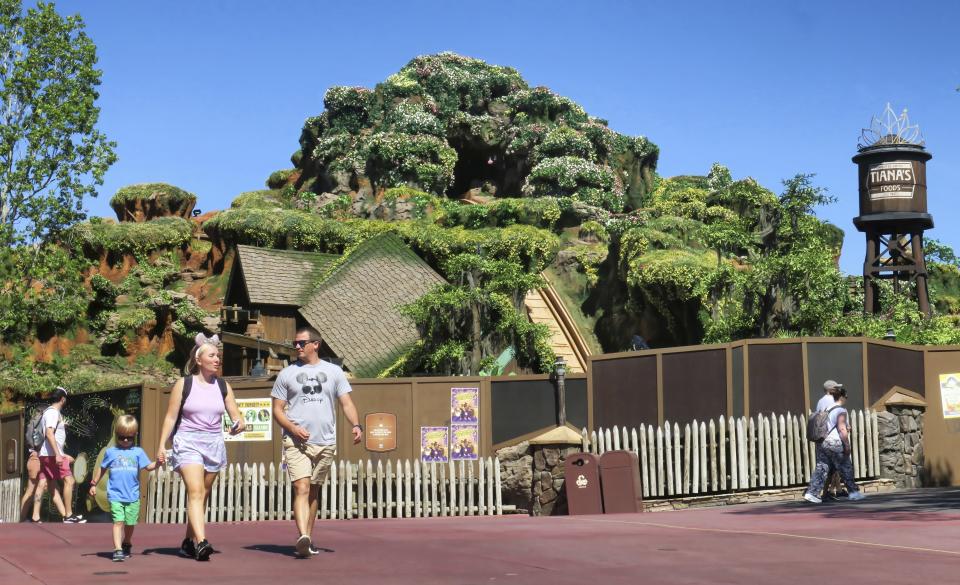 Guests pass by Tiana's Bayou Adventure, the reimagined former Splash Mountain ride in the Magic Kingdom at Walt Disney World, as work continues Thursday, May 23, 2024, ahead of its planned June 28 opening in Bay Lake, Fla. The attraction's new theme is based on the Disney film "The Princess and The Frog." (Joe Burbank /Orlando Sentinel via AP)