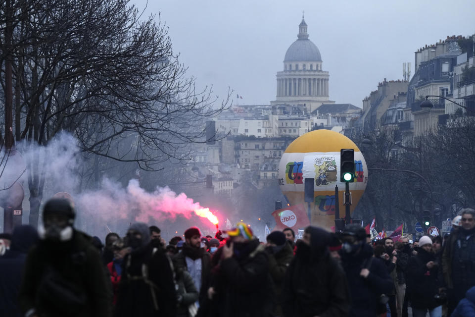 Protesters march, with the Pantheon monument in background, during a demonstration, Tuesday, March 7, 2023 in Paris. Demonstrators were marching across France on Tuesday in a new round of protests and strikes against the government's plan to raise the retirement age to 64, in what unions hope to be their biggest show of force against the proposal. (AP Photo/Lewis Joly)