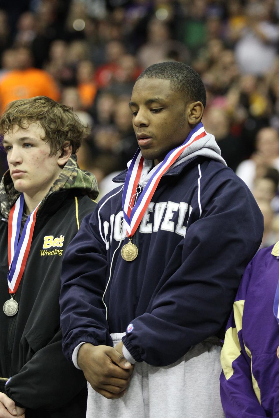 John Meeks receives his fourth state championship medal after his 138-pound match against Connor Ryan of Bettendorf.