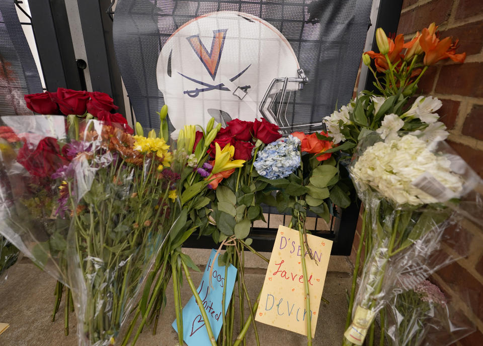 Memorial flowers and notes line the sidewalk at the University of Virginia's Scott Stadium in Charlottesville on Tuesday.  After three football players at the school were killed in a shooting on campus Sunday, Va.  (AP Photo/Steve Helber)