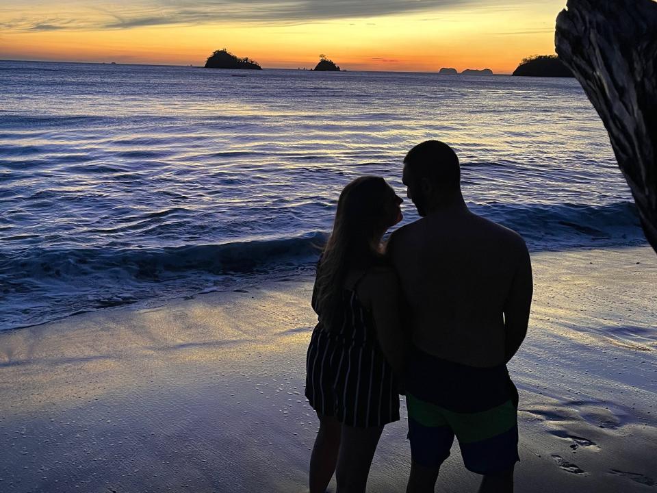 a couple on a beach at sunset