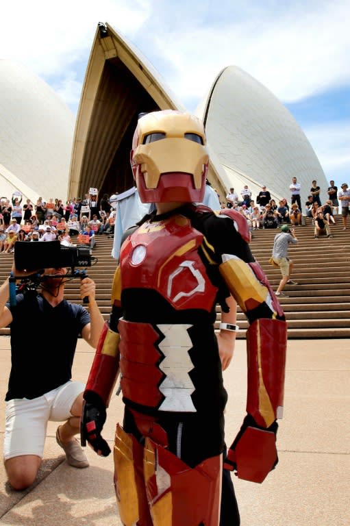 Nine-year-old Domenic Pace (R) acts out a scene as "Iron Boy" after police helped stage an elaborate event with the Make-A-Wish Foundation on the Sydney Opera House steps on February 11, 2016