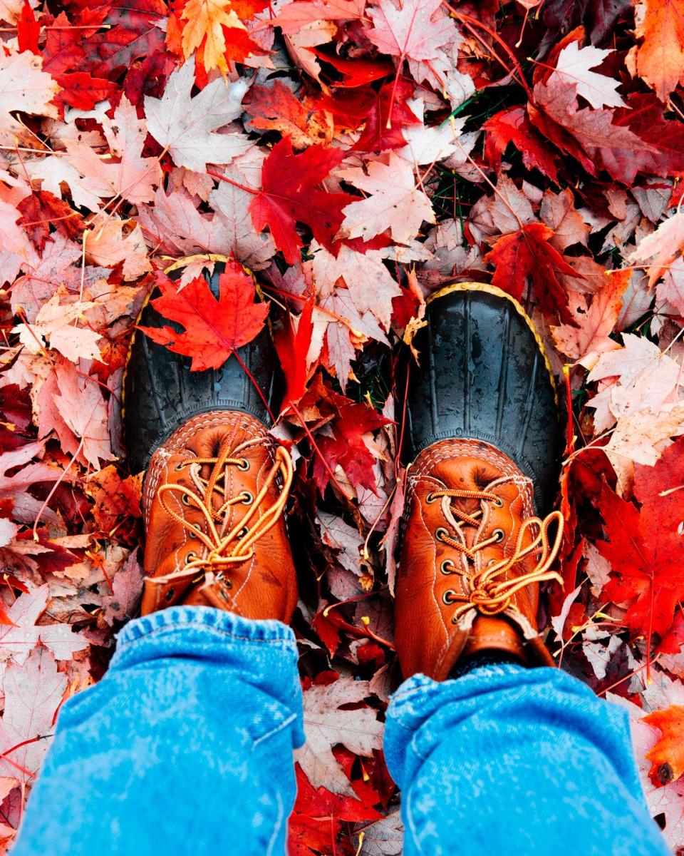 rain boots on red leaves strolling outside during autumn