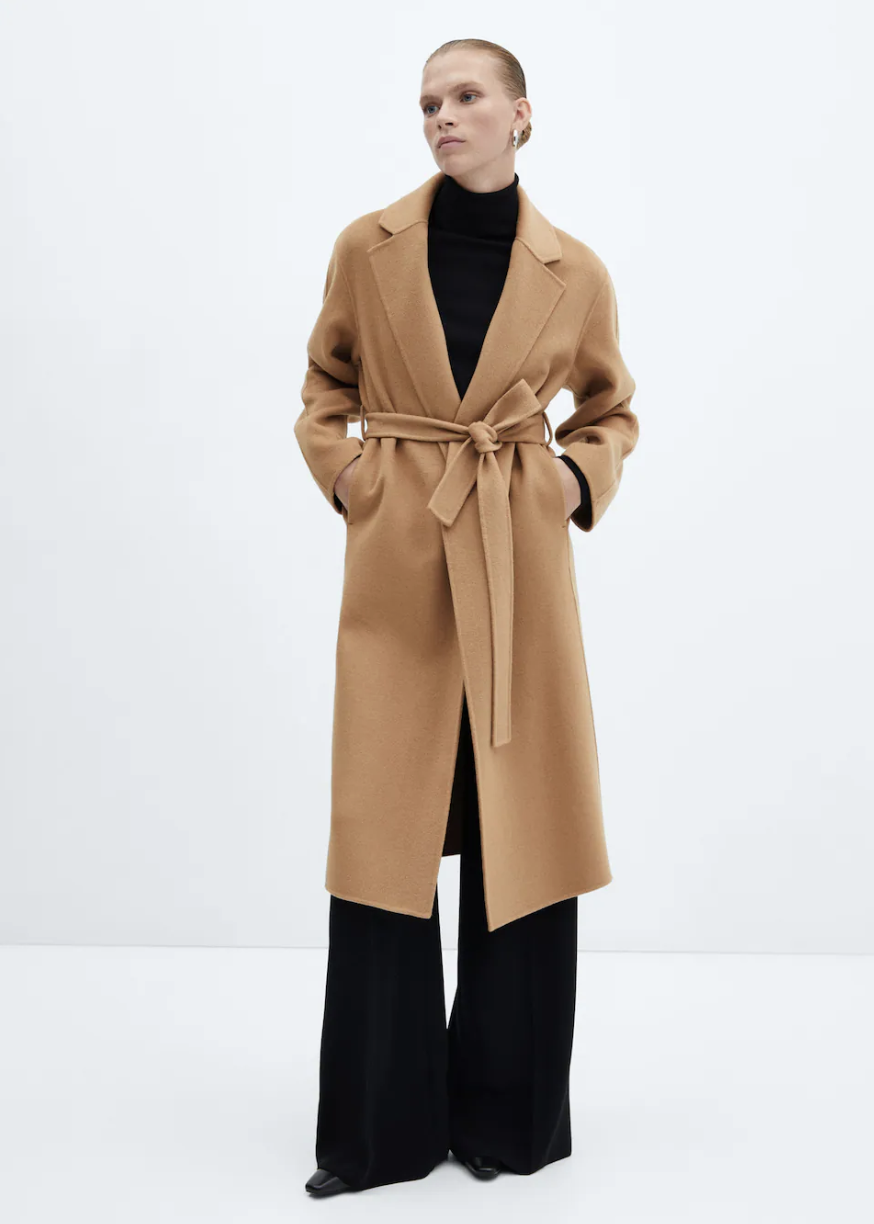 model wearing black wide leg pants, black turtleneck and camel Belt Handmade Coat in Medium Brown (Photo via Mango)