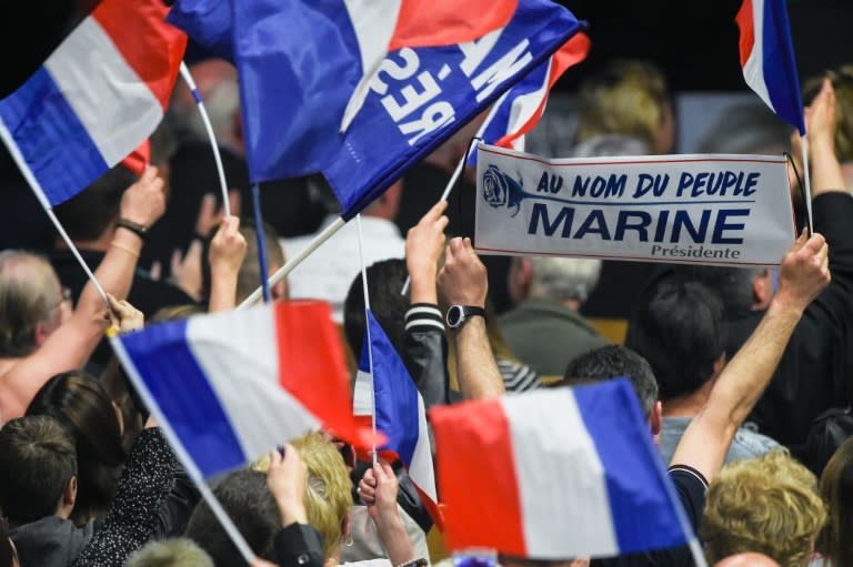 Supporters wave French flags during a rally of French presidential election candidate for the far-right Front National (FN) party Marine Le Pen, in Monswiller, north-eastern France, on April 5, 2017